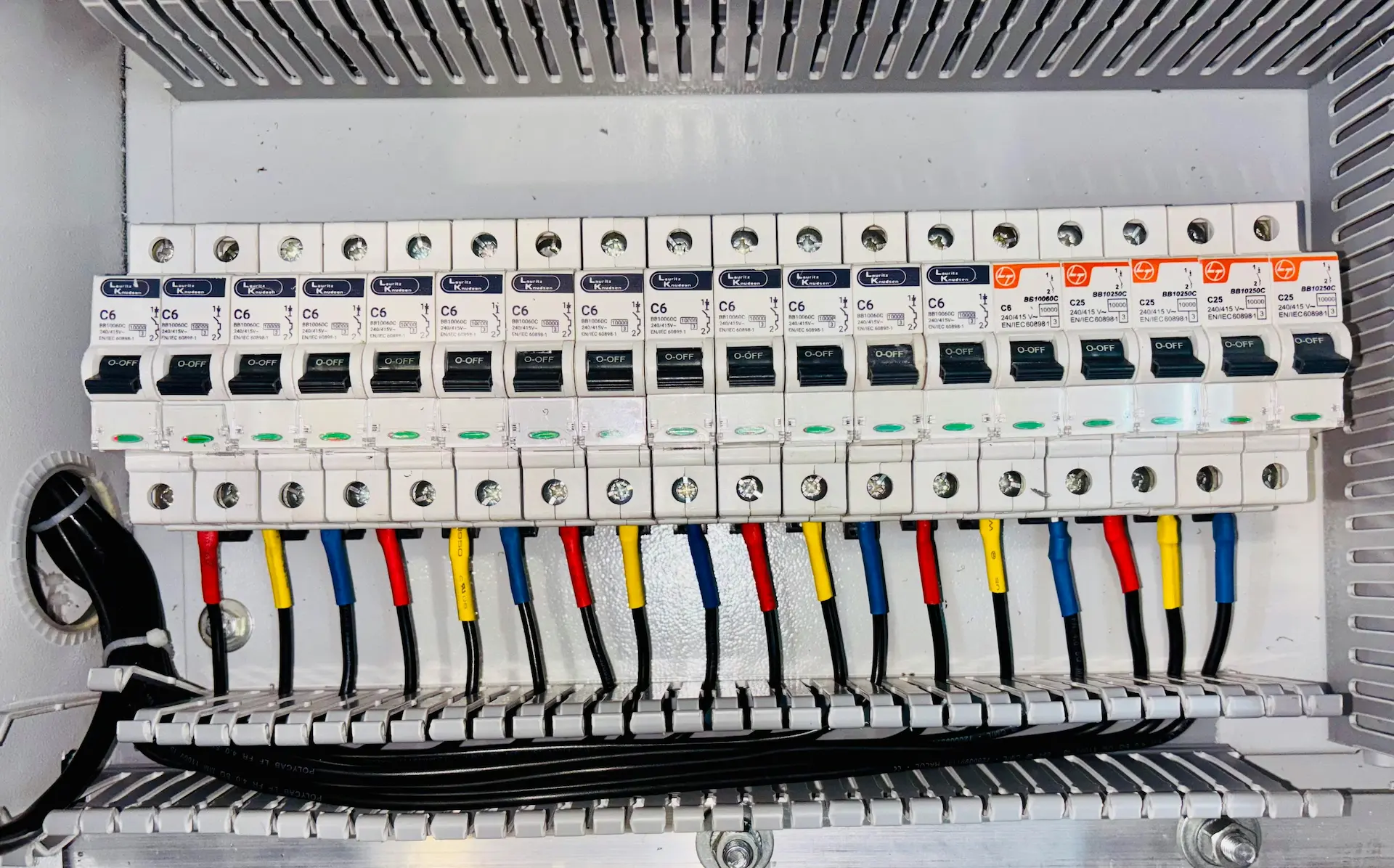 Wire ferrules installed on DIN rail terminal strip in industrial control panel